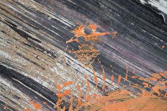 Abstract canvas artwork with bold orange accents and dynamic shapes.