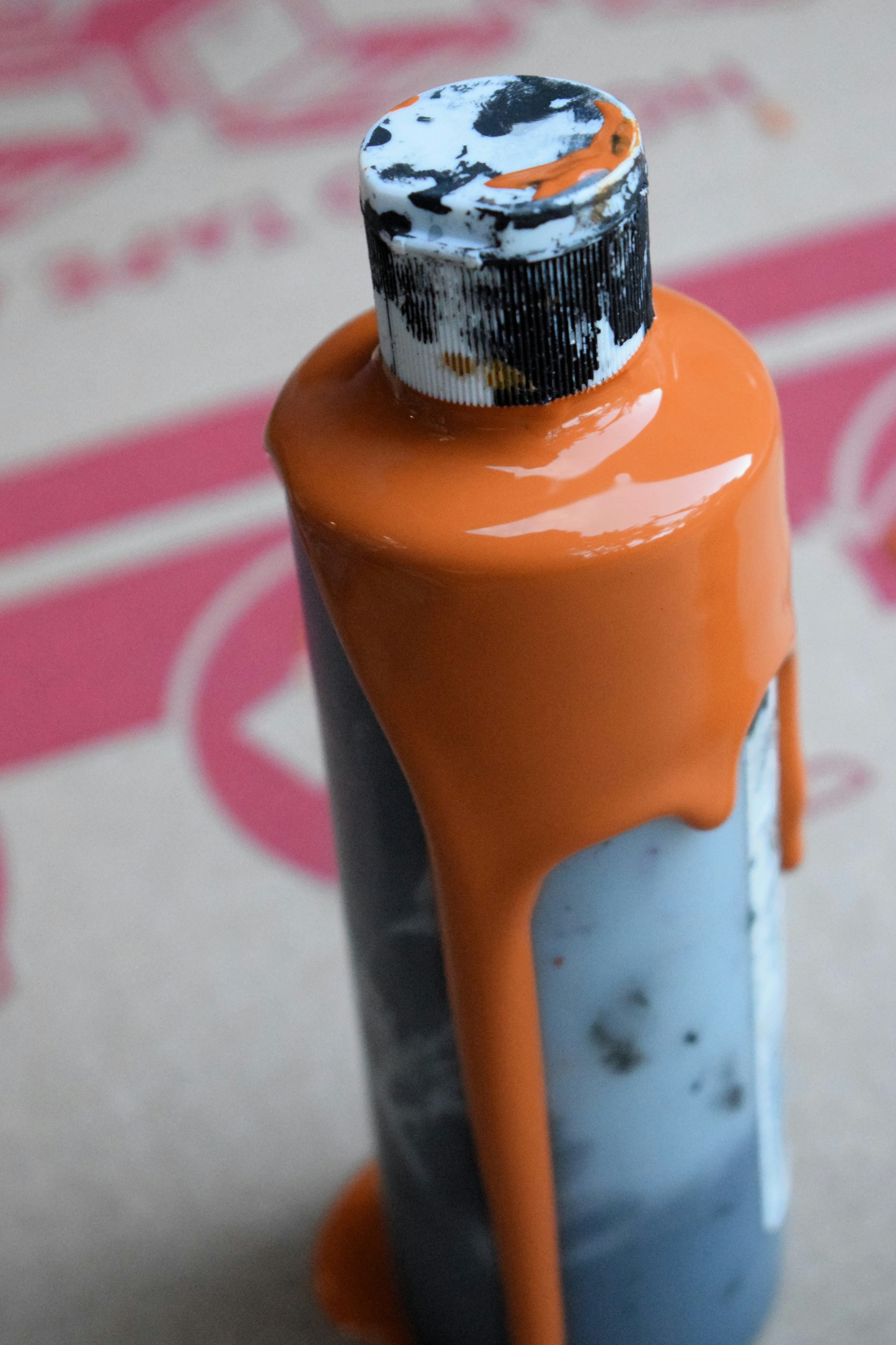 an orange and gray bottle with a black cap