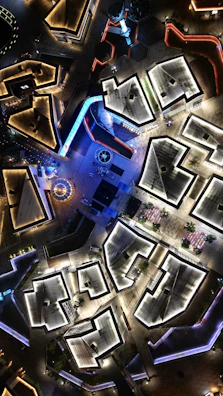 Aerial view of a geometric urban layout with sharp angles and contrasting shadows.