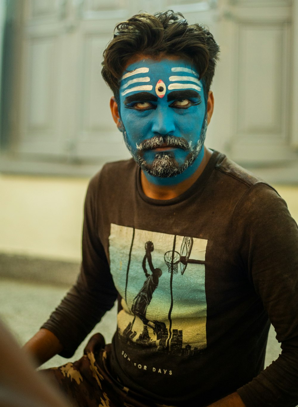 a man with a painted face sitting down