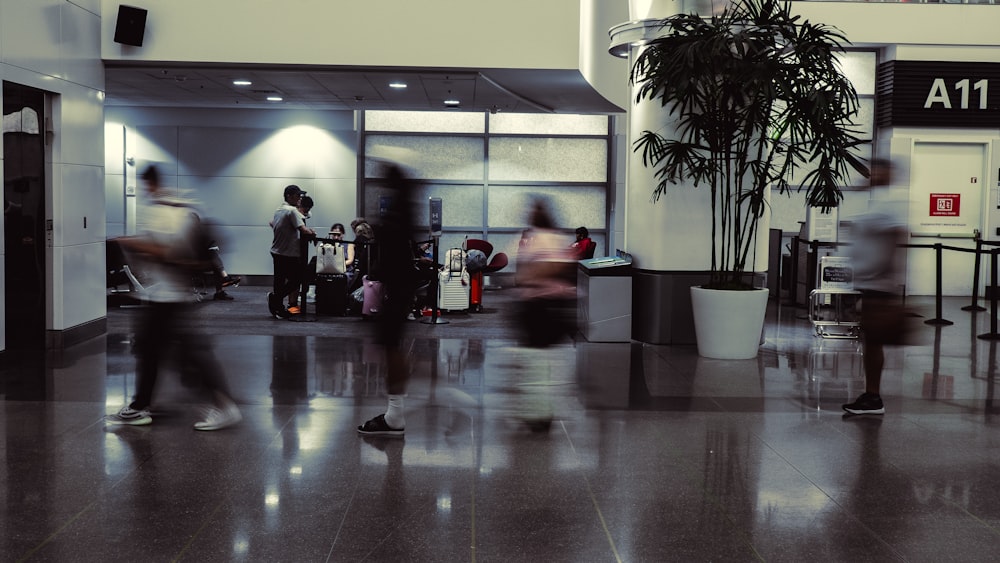 a group of people walking through an airport lobby