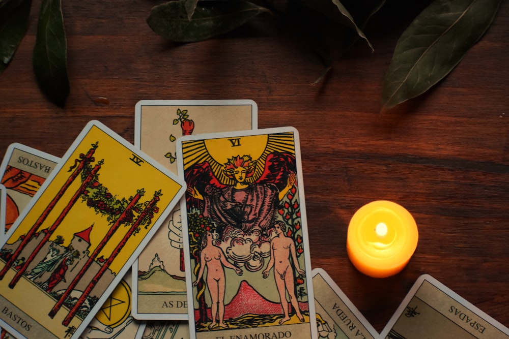 a candle sitting next to a set of tarot cards