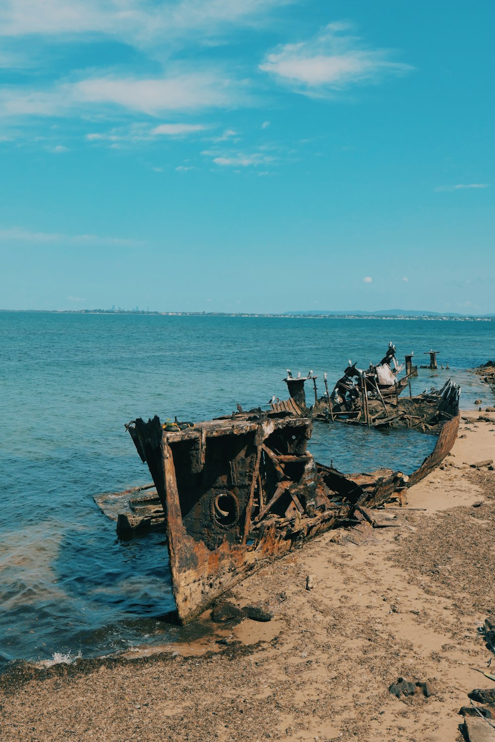 a boat sitting on top of a beach next to the ocean