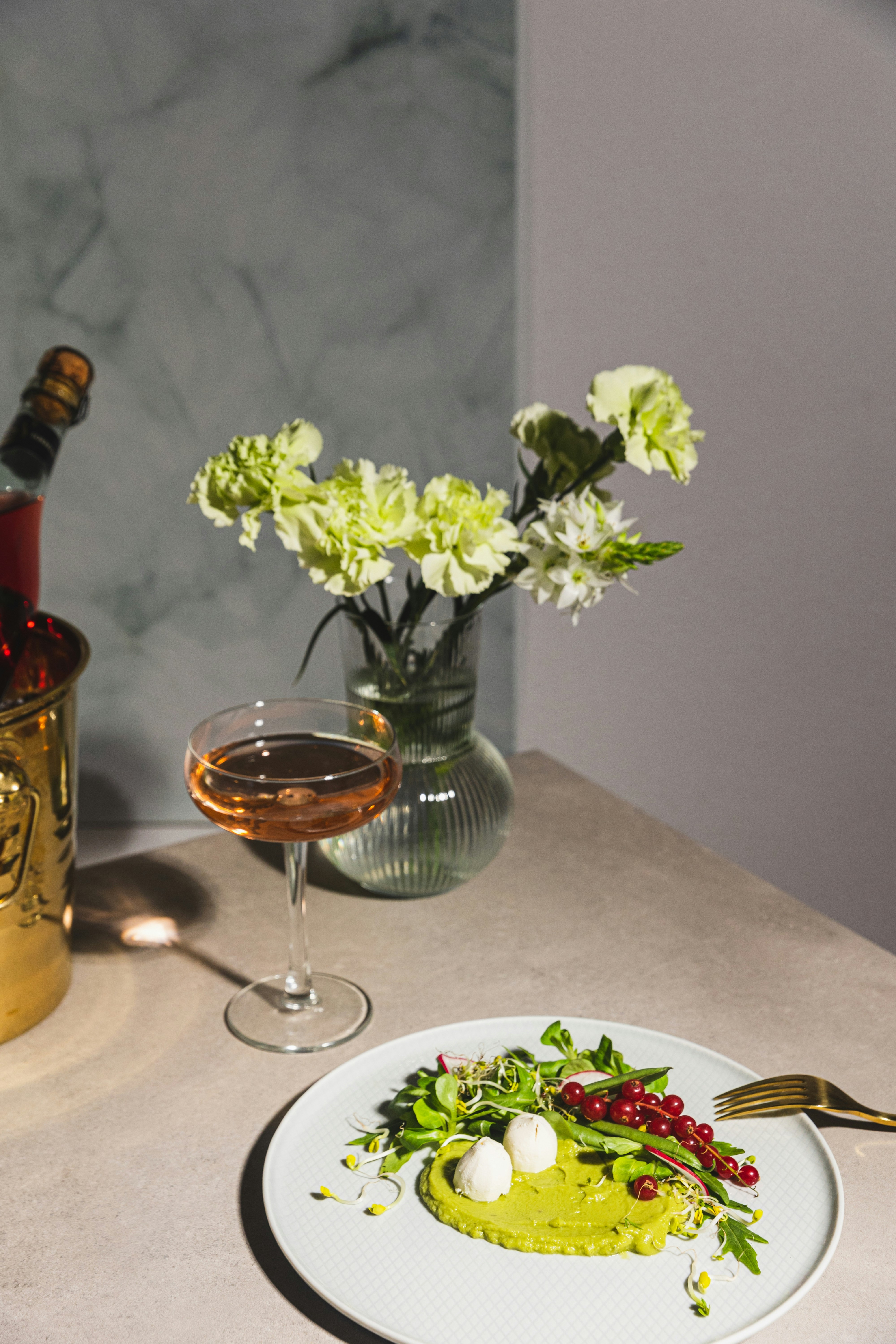 ein weißer Teller mit Essen neben einem Glas Wein