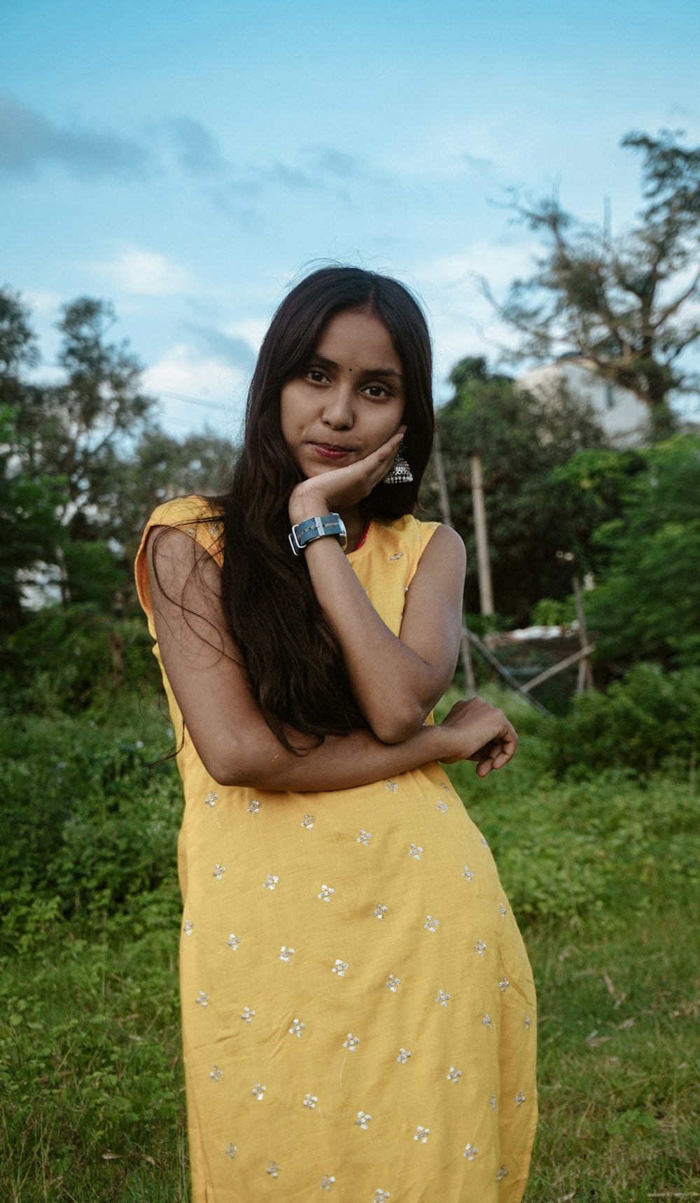 a woman in a yellow dress posing for a picture