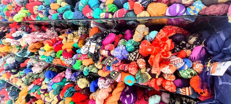 Close-up of colorful fabric rolls stacked in a vibrant garment workshop.