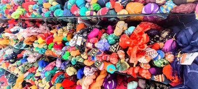Rows of colorful fabric rolls neatly stacked in a vibrant textile factory.