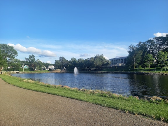A scenic view of the community center surrounded by fresh green lawns and bright yellow flowers.