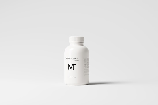 A white plastic bottle with a screw top, labeled 'Medicine Bottle mockup' and the letters 'MF' in bold. The bottle is placed against a plain, light gray background, with some small text details visible on the right side.