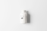 A white plastic bottle positioned centrally against a white background, featuring the label 'Medicine Bottle Mockup MF' in simple black text. The bottle has a smooth surface with a screw cap and additional small print details on the label.