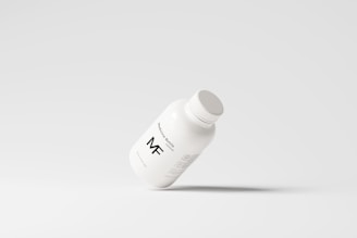 A simplistic and modern design featuring a medicine bottle floating against a light grey background, with minimalistic labeling and a clean appearance.