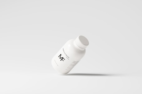 A simplistic and modern design featuring a medicine bottle floating against a light grey background, with minimalistic labeling and a clean appearance.