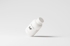 A simplistic and modern design featuring a medicine bottle floating against a light grey background, with minimalistic labeling and a clean appearance.