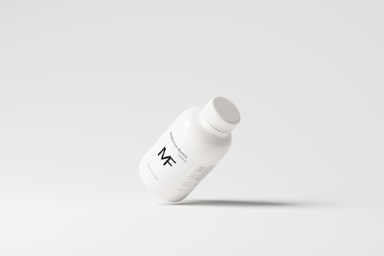 A simplistic and modern design featuring a medicine bottle floating against a light grey background, with minimalistic labeling and a clean appearance.