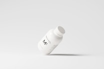 A simplistic and modern design featuring a medicine bottle floating against a light grey background, with minimalistic labeling and a clean appearance.