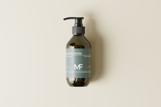 A green, transparent pump bottle with a label displaying the text 'Cosmetic Bottle' and 'MF'. It is set against a plain, light background, casting a soft shadow to the right.