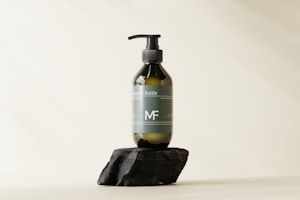 Elegant pump bottle of hydrating serum on white surface with subtle botanical shadows