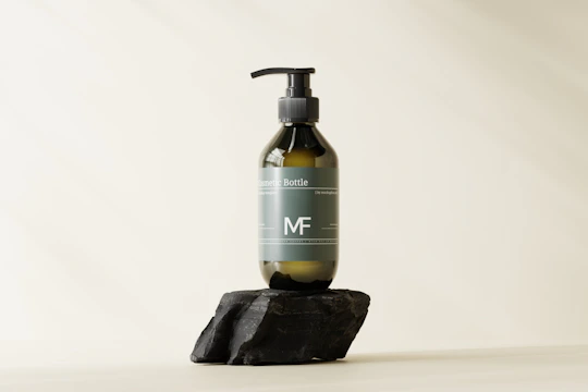 Elegant bottle of scalp care serum with minimalist Italian-inspired packaging on a stone surface.