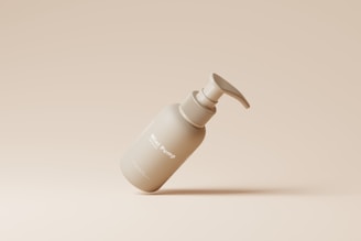 A minimalist bottle with a pump dispenser is gracefully positioned in a floating manner against a beige background. The bottle has a smooth matte finish with the text 'Mini Pump' clearly visible.
