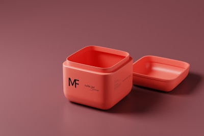 A vibrant orange jar with a black wolf logo sitting on a wooden table.