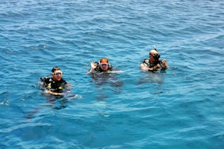 three people in the water wearing scuba gear