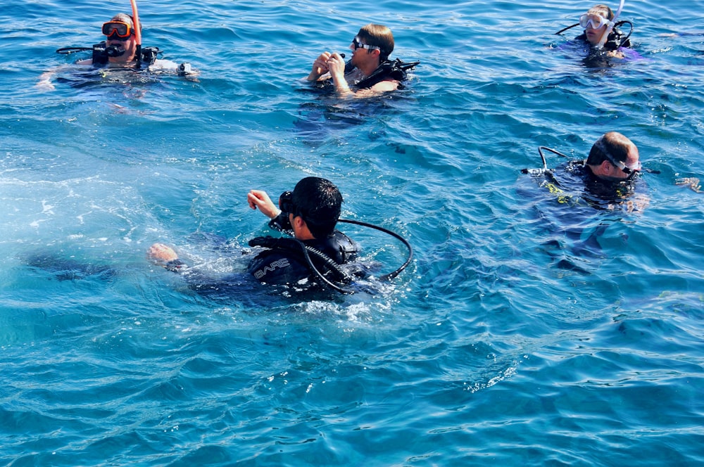 um grupo de pessoas na água com equipamento de mergulho