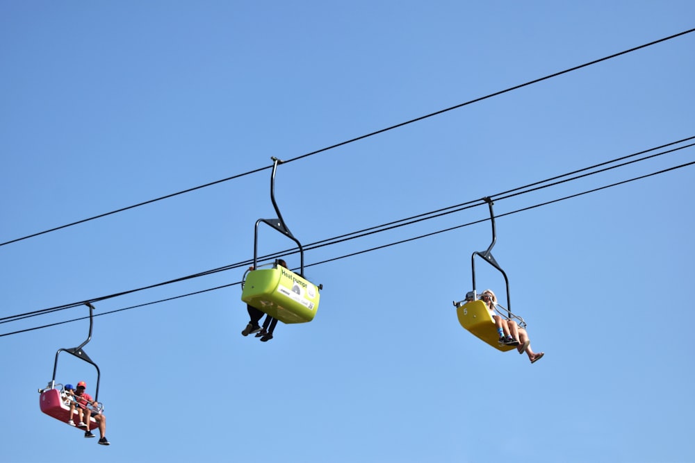 a couple of people riding on top of a ski lift