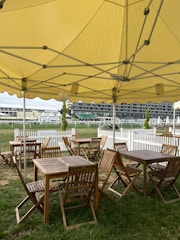 Temporary seating arrangements with chairs and tables under a tent.