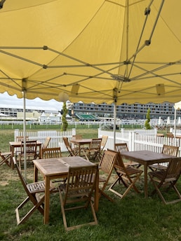A cozy outdoor seating area shaded by a sturdy, stylish tent on a sunny day.