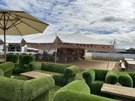 An outdoor networking session with attendees sharing stories over coffee in a sunny courtyard.