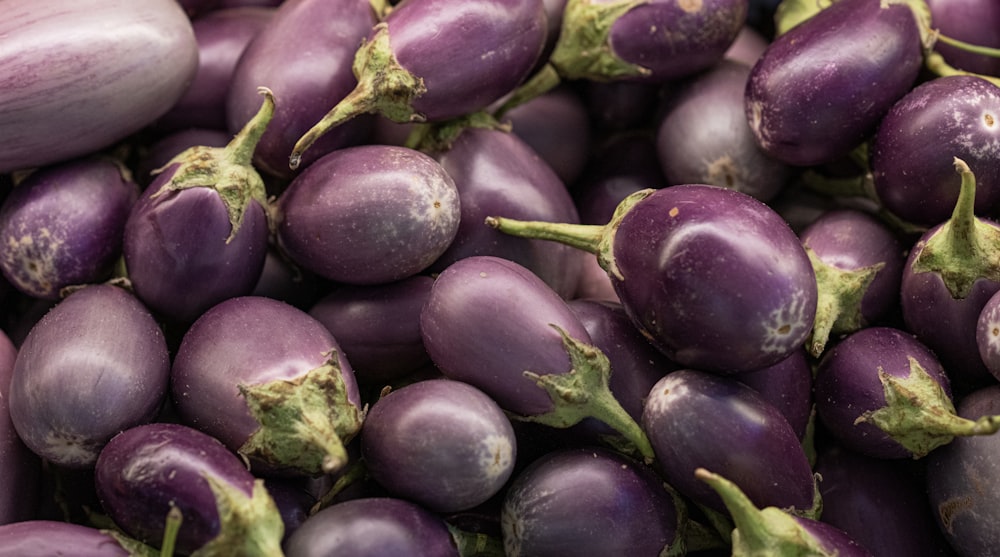 a pile of purple eggplant sitting on top of each other