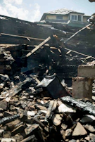 Charred wooden beams being carefully removed from a residential property after fire damage.