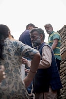 An elder village leader discussing community matters with residents.