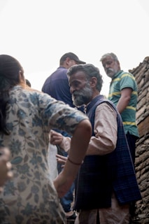 An elder village leader discussing community matters with residents.