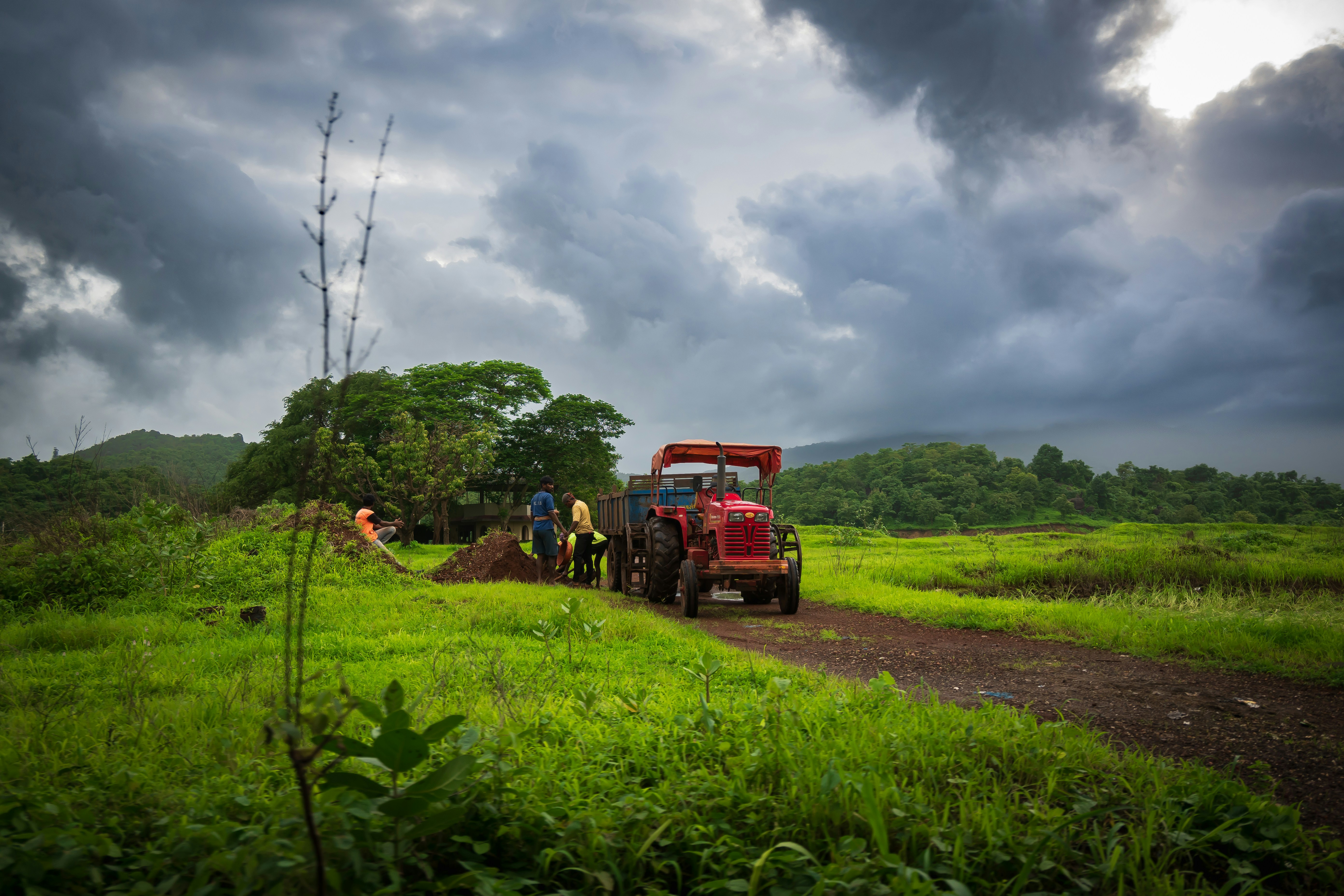 a tractor is parked on the side of a dirt road