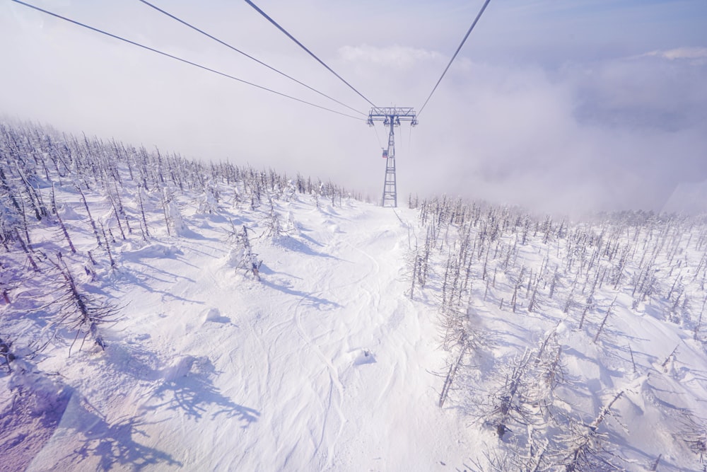 a ski lift going over a snow covered ski slope
