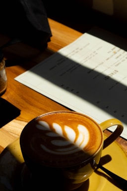 a cappuccino sits on a saucer on a table