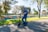 A happy customer riding an electric scooter in a park.