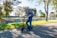 A person happily riding a mobility scooter in a park.