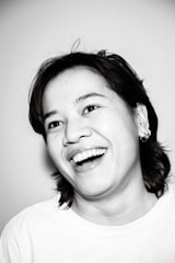 A vibrant portrait of a smiling individual outdoors.