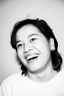 An artistic black and white portrait of a smiling individual.