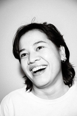 An artistic black and white portrait of a smiling individual.