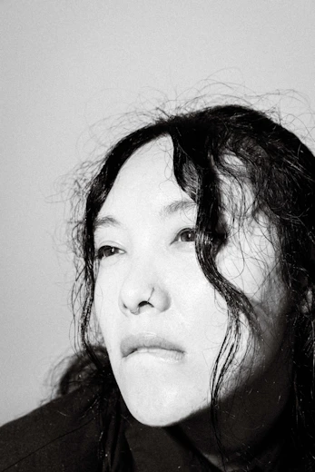 a black and white photo of a woman with wet hair