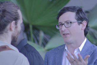 A consultant discussing environmental plans with a client outdoors surrounded by greenery.