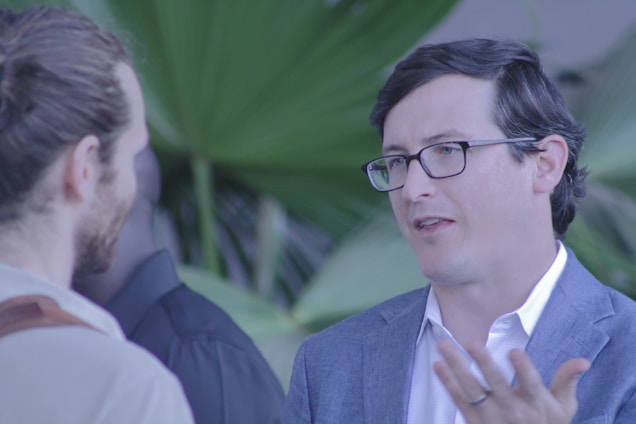 A professional health manager coaching a client outdoors with vibrant greenery in the background.