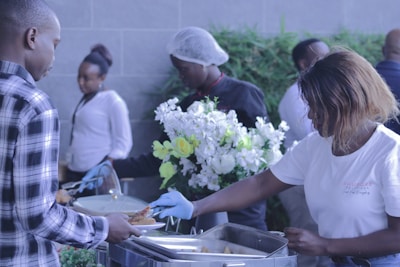 Friendly staff serving food at a welcoming event reception.