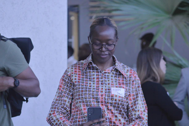A casual social gathering where someone subtly glances at their phone, relieved.