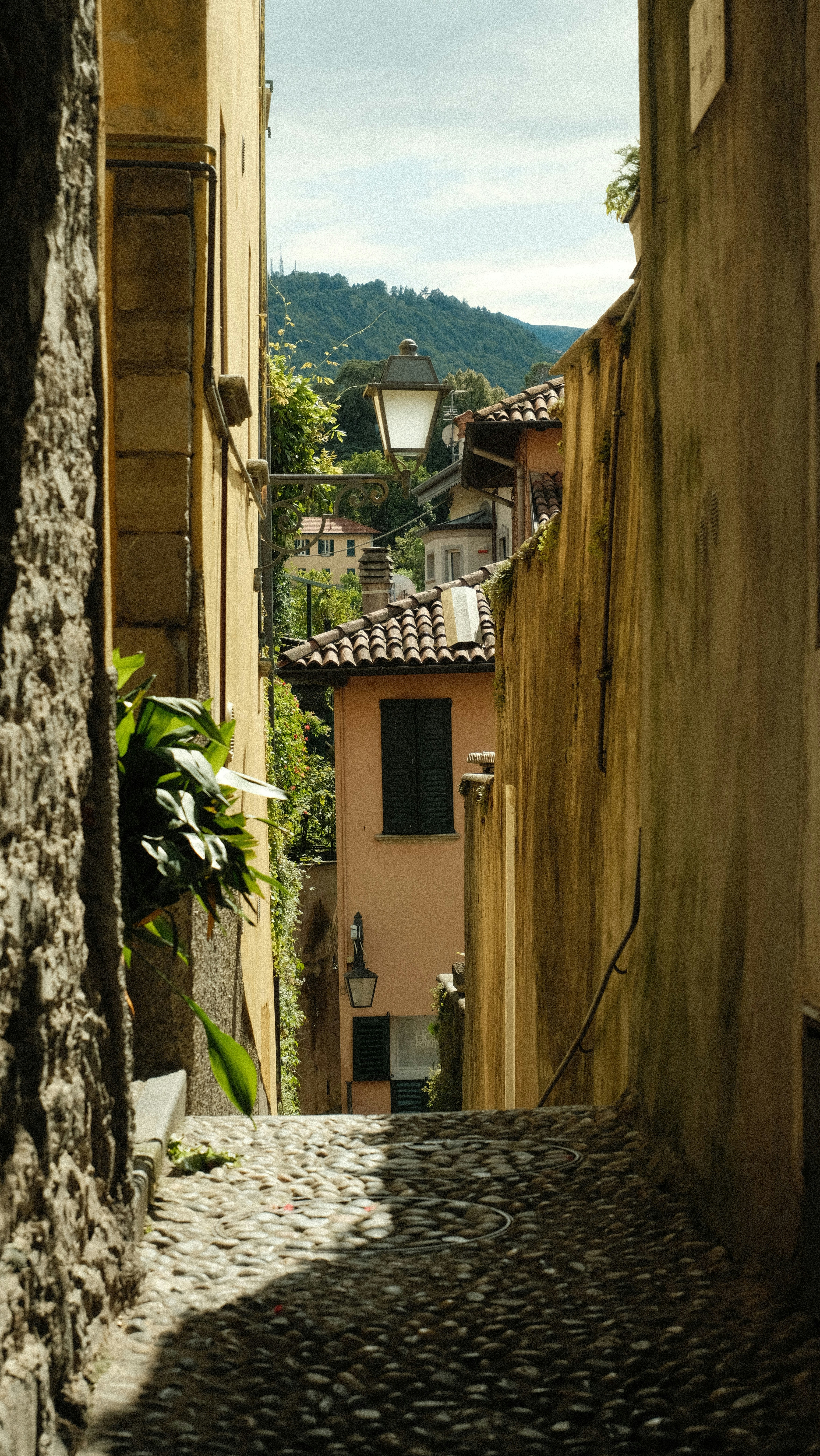 a narrow alley way with a clock tower in the distance