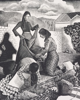 Three figures engaged in communal work outdoors. A woman in a long dress holds a large piece of fabric while another woman kneels, assisting with the fabric. A third person, bending over, works on the ground, surrounded by a basket and patterned textiles. The background shows trees, hills, a house, and a cloudy sky, creating a rural and serene setting.