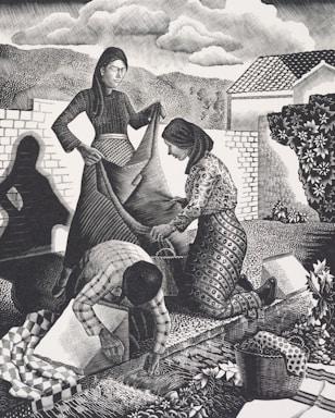 Three figures engaged in communal work outdoors. A woman in a long dress holds a large piece of fabric while another woman kneels, assisting with the fabric. A third person, bending over, works on the ground, surrounded by a basket and patterned textiles. The background shows trees, hills, a house, and a cloudy sky, creating a rural and serene setting.